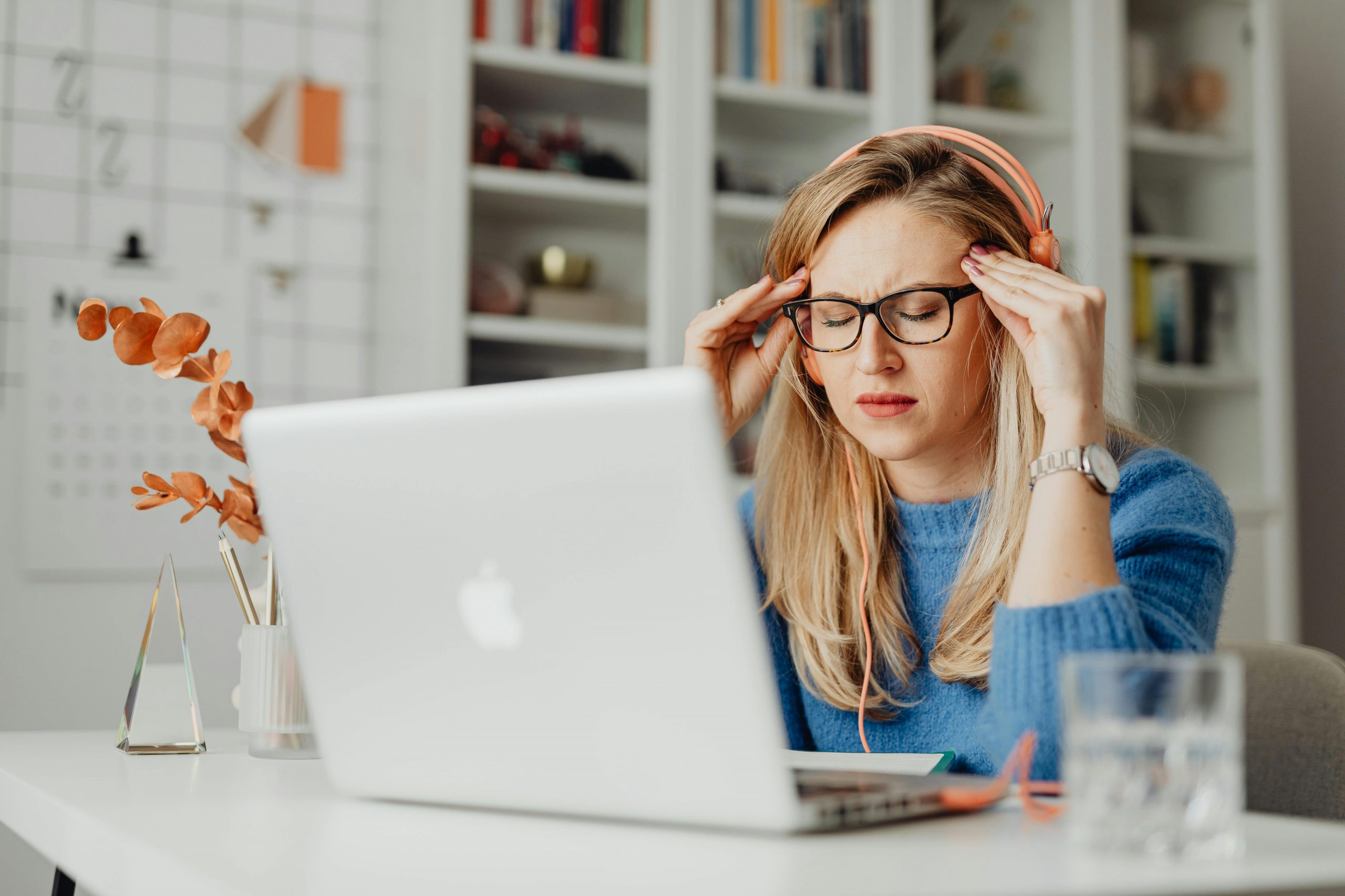 stressed woman sitting in front of an open laptop