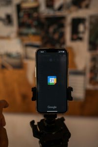 smartphone mounted on a tripod, with the screen displaying the Google Calendar icon