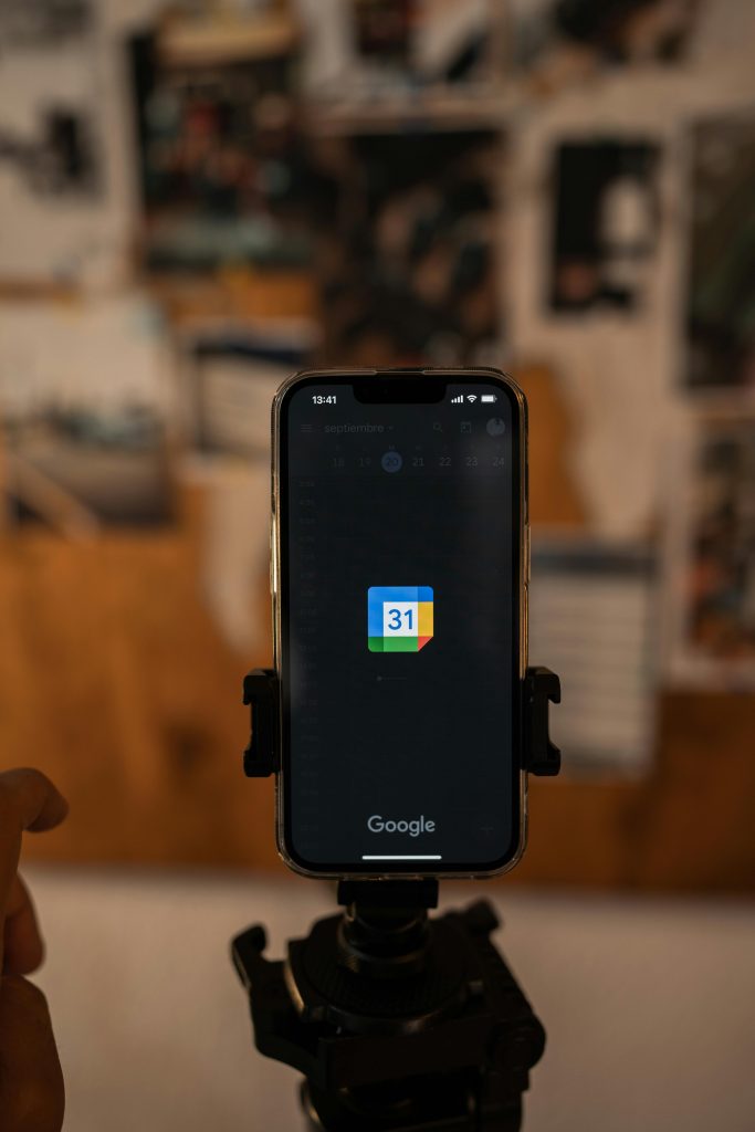 smartphone mounted on a tripod, with the screen displaying the Google Calendar icon